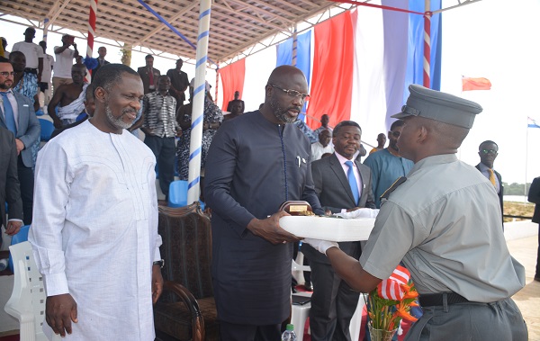 Handing over a token of appreciation to HE President Weah